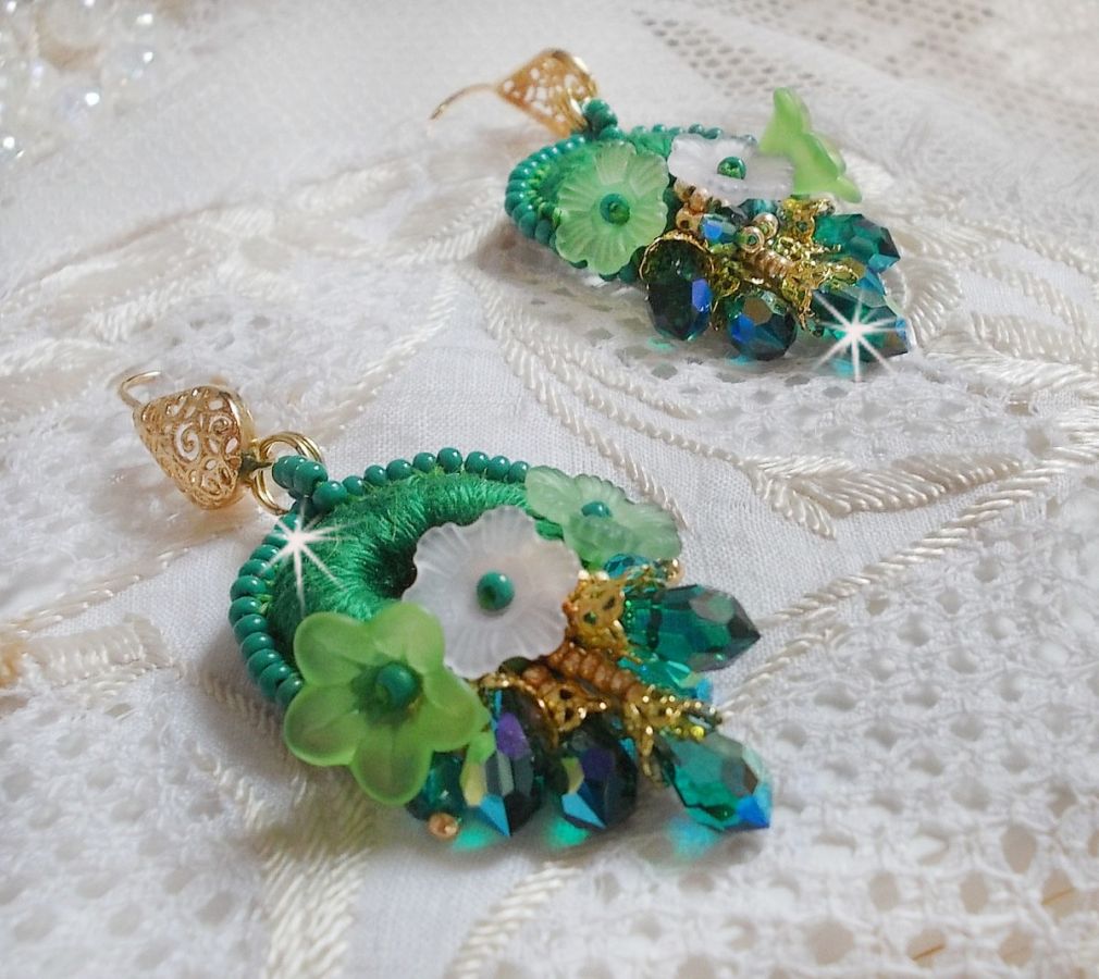 BO Green Iris brod&eacute;es avec du coton DMC Vert sur des anneaux en bois &agrave; laquelle s&rsquo;ajoute des gouttes en cristal, fleurs lucites et rocailles. Mont&eacute;s sur boucles en Laiton. Un style Contemporain !