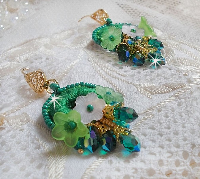 BO Green Iris brod&eacute;es avec du coton DMC Vert sur des anneaux en bois &agrave; laquelle s&rsquo;ajoute des gouttes en cristal, fleurs lucites et rocailles. Mont&eacute;s sur boucles en Laiton. Un style Contemporain !