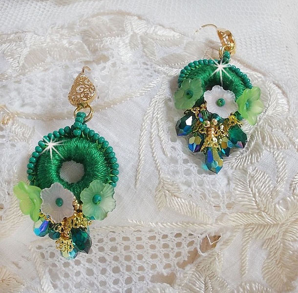 BO Green Iris brod&eacute;es avec du coton DMC Vert sur des anneaux en bois &agrave; laquelle s&rsquo;ajoute des gouttes en cristal, fleurs lucites et rocailles. Mont&eacute;s sur boucles en Laiton. Un style Contemporain !