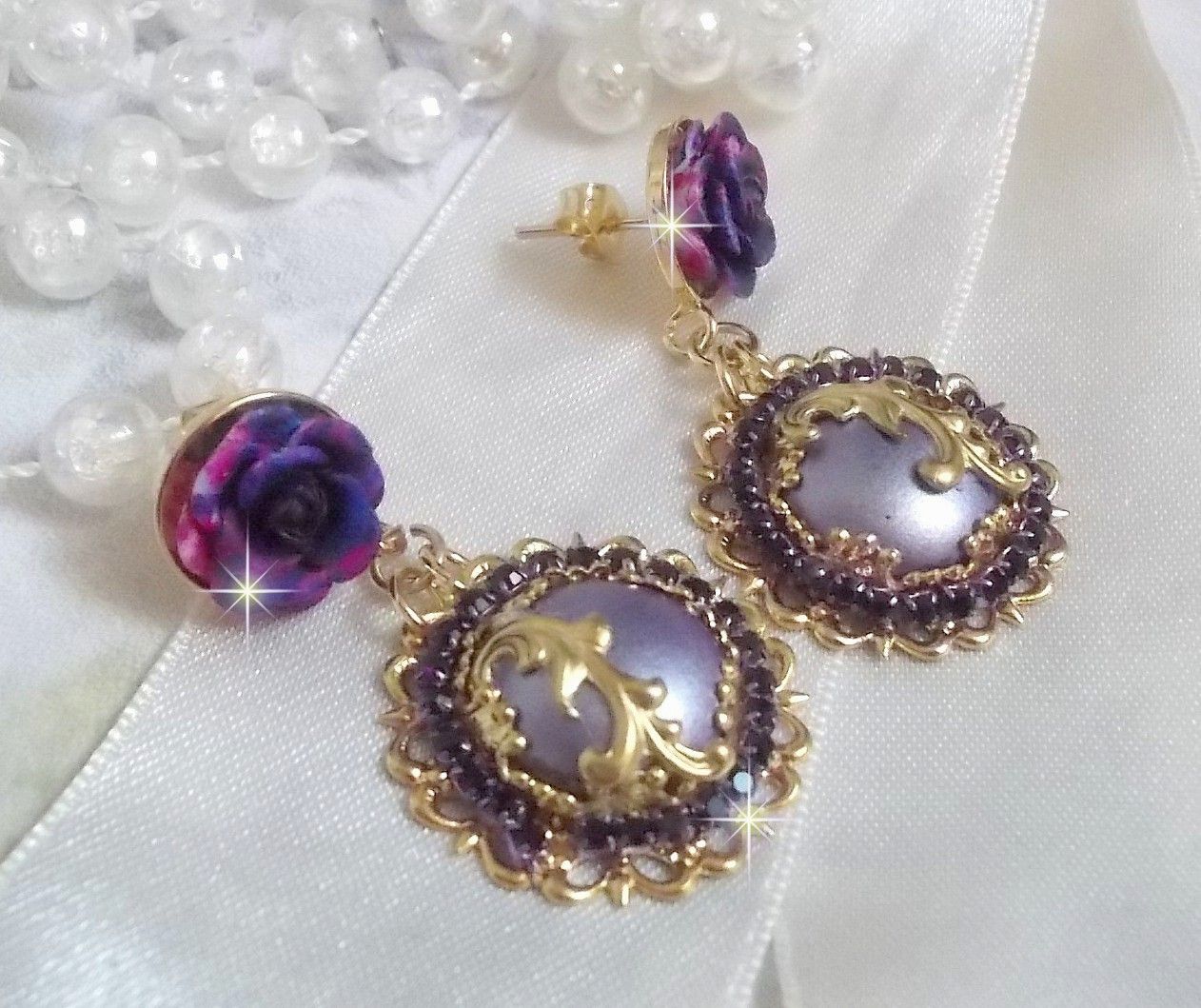 BO Illusions Merveilleuses cr&eacute;&eacute;es avec des cabochons mauve en verre, des entretoises dor&eacute;es et strass&eacute;es de couleur Am&eacute;thyste, estampes filigran&eacute;es, clous d'oreilles dor&eacute;es