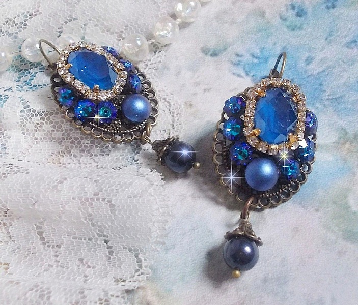 BO Leila avec des cabochons ovales de couleur Royal Blue &agrave; laquelle s&rsquo;ajoute des cabochons ronds, perles nacr&eacute;es et fleurs. Ils sont tous en Cristal, les dormeuses couleur Bronze sont en Laiton