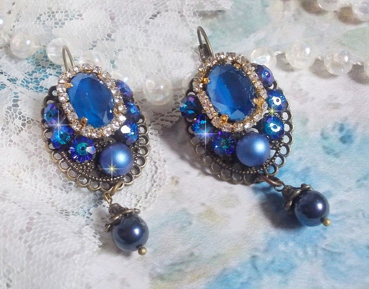 BO Leila avec des cabochons ovales de couleur Royal Blue &agrave; laquelle s&rsquo;ajoute des cabochons ronds, perles nacr&eacute;es et fleurs. Ils sont tous en Cristal, les dormeuses couleur Bronze sont en Laiton
