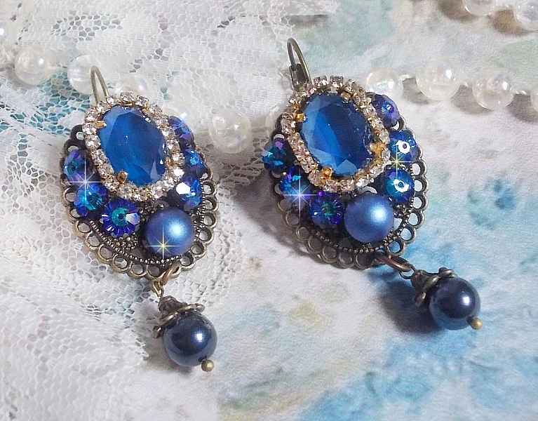 BO Leila avec des cabochons ovales de couleur Royal Blue &agrave; laquelle s&rsquo;ajoute des cabochons ronds, perles nacr&eacute;es et fleurs. Ils sont tous en Cristal, les dormeuses couleur Bronze sont en Laiton