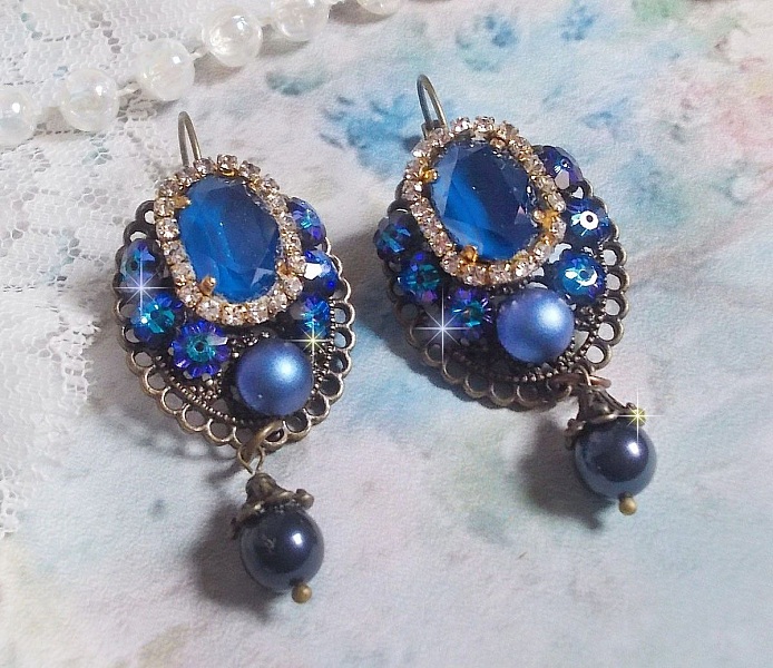 BO Leila avec des cabochons ovales de couleur Royal Blue &agrave; laquelle s&rsquo;ajoute des cabochons ronds, perles nacr&eacute;es et fleurs. Ils sont tous en Cristal, les dormeuses couleur Bronze sont en Laiton