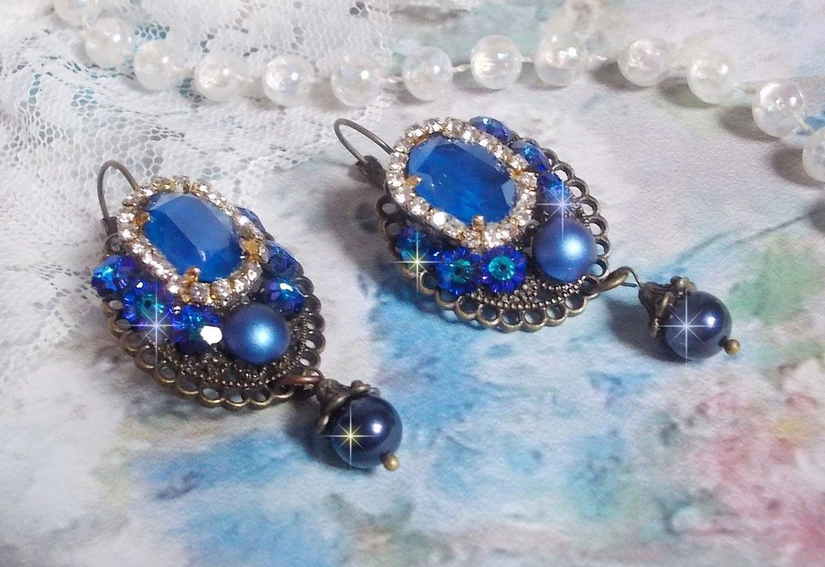 BO Leila avec des cabochons ovales de couleur Royal Blue &agrave; laquelle s&rsquo;ajoute des cabochons ronds, perles nacr&eacute;es et fleurs. Ils sont tous en Cristal, les dormeuses couleur Bronze sont en Laiton