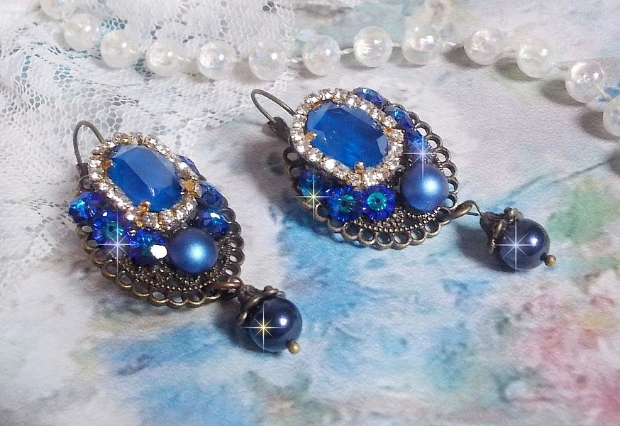 BO Leila avec des cabochons ovales de couleur Royal Blue &agrave; laquelle s&rsquo;ajoute des cabochons ronds, perles nacr&eacute;es et fleurs. Ils sont tous en Cristal, les dormeuses couleur Bronze sont en Laiton