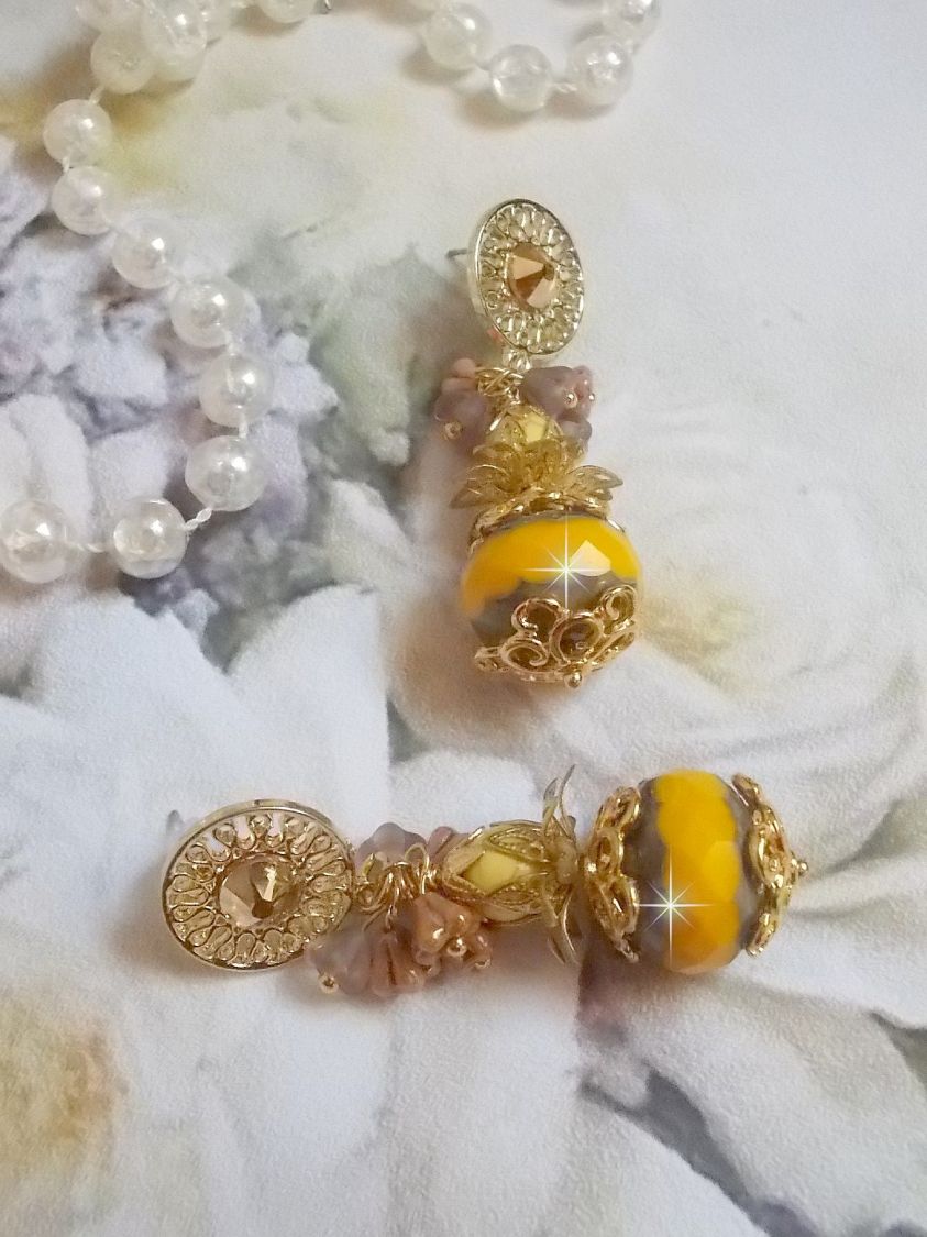 BO Lumi&egrave;re Opale Jaune avec des perles potirons jaunes &agrave; laquelle s&rsquo;ajoute des fleurs, cabochons en cristal, coupelles et perles rondes. Mont&eacute;s sur clous d&rsquo;oreilles en M&eacute;tal. Un style moderne