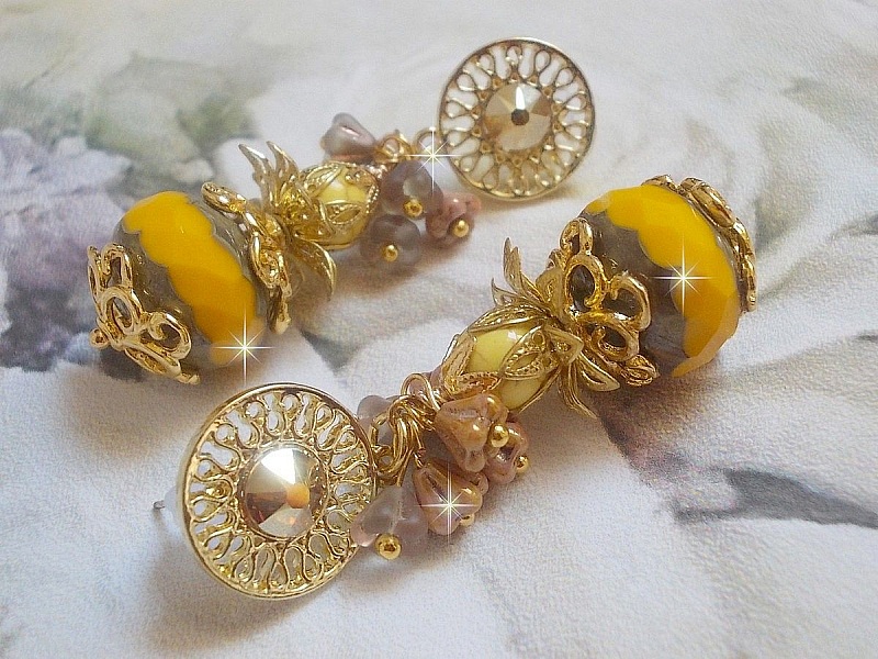 BO Lumi&egrave;re Opale Jaune avec des perles potirons jaunes &agrave; laquelle s&rsquo;ajoute des fleurs, cabochons en cristal, coupelles et perles rondes. Mont&eacute;s sur clous d&rsquo;oreilles en M&eacute;tal. Un style moderne