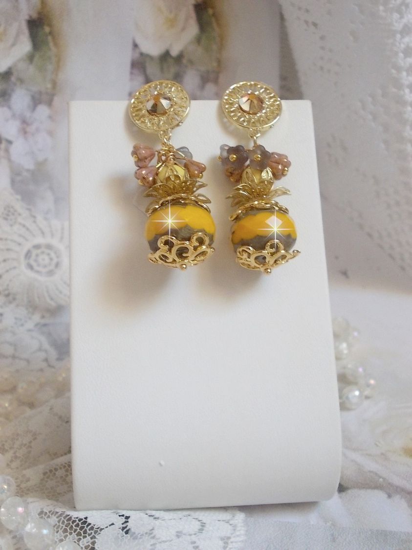 BO Lumi&egrave;re Opale Jaune avec des perles potirons jaunes &agrave; laquelle s&rsquo;ajoute des fleurs, cabochons en cristal, coupelles et perles rondes. Mont&eacute;s sur clous d&rsquo;oreilles en M&eacute;tal. Un style moderne