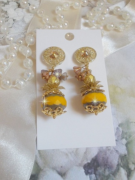 BO Lumi&egrave;re Opale Jaune avec des perles potirons jaunes &agrave; laquelle s&rsquo;ajoute des fleurs, cabochons en cristal, coupelles et perles rondes. Mont&eacute;s sur clous d&rsquo;oreilles en M&eacute;tal. Un style moderne
