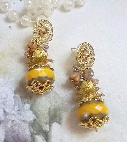 BO Lumi&egrave;re Opale Jaune avec des perles potirons jaunes &agrave; laquelle s&rsquo;ajoute des fleurs, cabochons en cristal, coupelles et perles rondes. Mont&eacute;s sur clous d&rsquo;oreilles en M&eacute;tal. Un style moderne