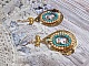 BO Mademoiselle Noellia avec des cabochons ovales repr&eacute;sentant une femme avec un chapeau et un n&oelig;ud blanc &agrave; laquelle s&rsquo;ajoute des cristaux, cha&icirc;nes strass P&ecirc;che et Turquoise sur crochets en plaqu&eacute; Or