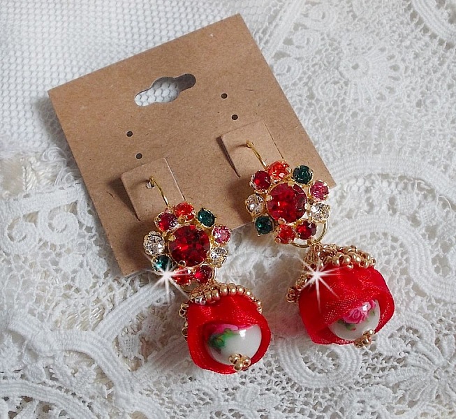 BO Mia avec des perles rondes Fimo avec des Roses, mont&eacute;es avec des coupelles filigran&eacute;es en Plaqu&eacute; Or avec du ruban organza Rouge &agrave; laquelle s&rsquo;ajoute des cabochons ronds sur dormeuses en Laiton