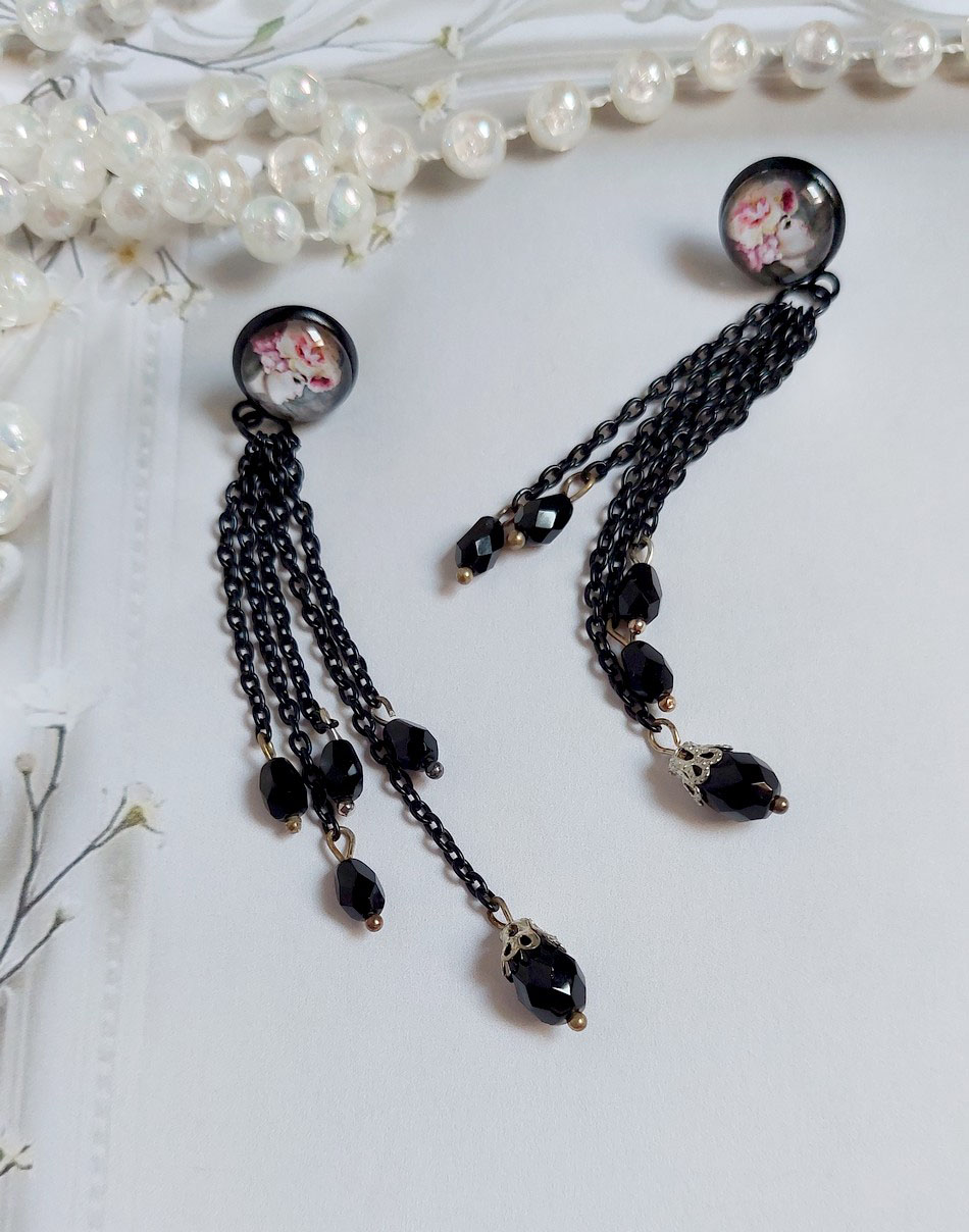 Boucles d'oreilles bohèmes noires avec chaînes et perles facettées.