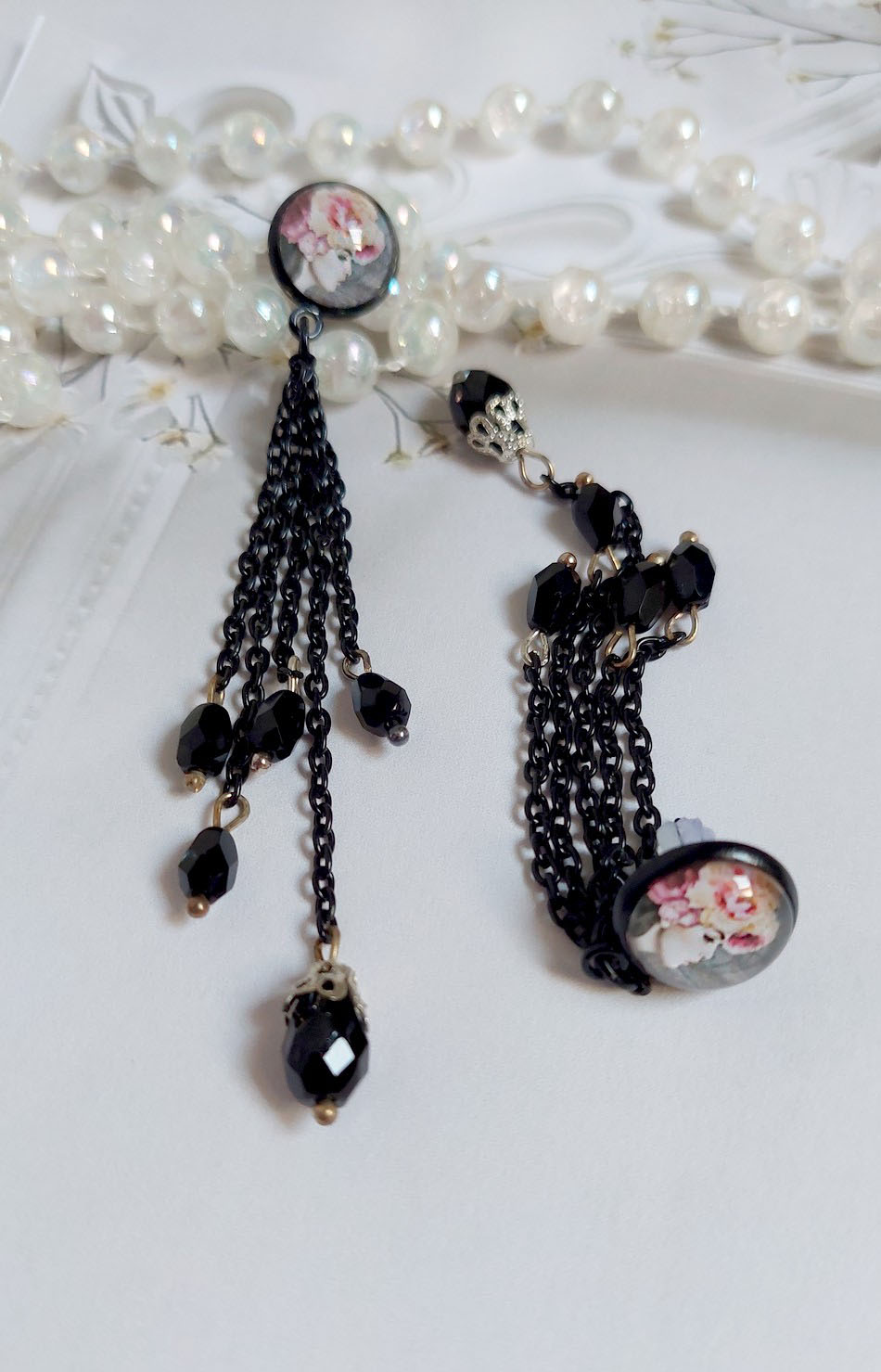 Boucles d'oreilles bohèmes noires avec cabochons roses et chaînettes.