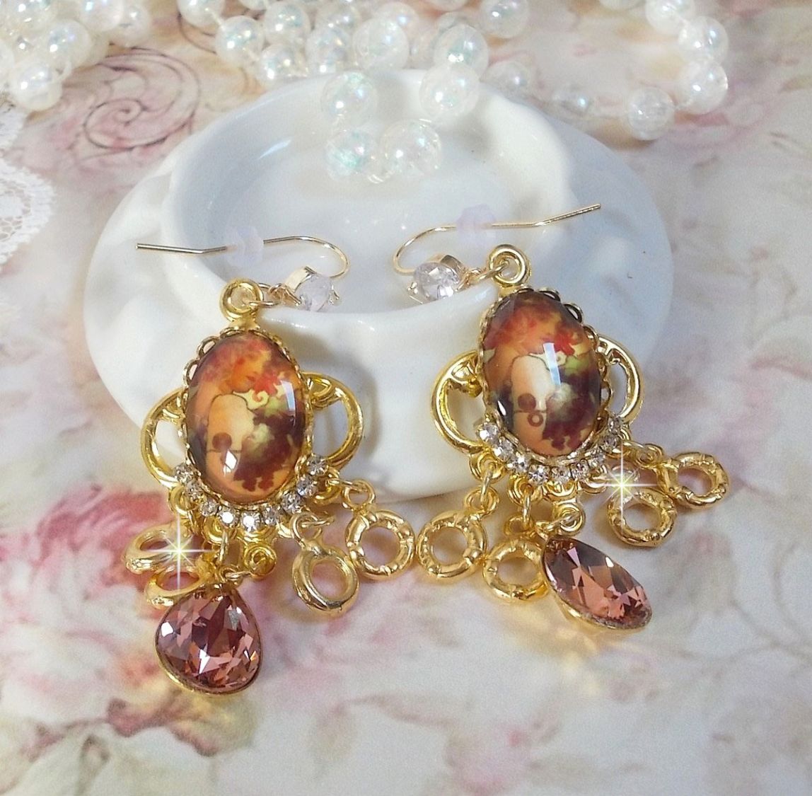 BO Paris repr&eacute;sentant une jeune femme &agrave; Paris, orn&eacute; d&rsquo;une cha&icirc;ne strass Cristal/Dor&eacute; avec des breloques, des pendants ovales Blush Rose, mont&eacute;s sur des crochets en plaqu&eacute; Or. Paris en mode vintage.