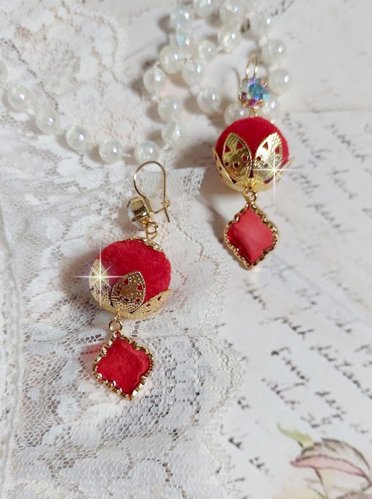 BO Passionn&eacute;ment mont&eacute;es avec des pompons Rouges tr&egrave;s tendances &agrave; laquelle s&rsquo;ajoute des coupelles en forme d&rsquo;arabesque, pendentifs vitrail Rouge/Dor&eacute; et cabochons en Cristal AB sur crochets en Laiton