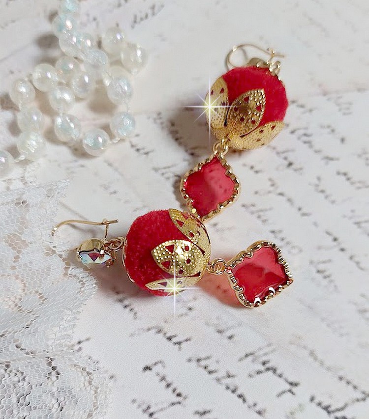 BO Passionn&eacute;ment mont&eacute;es avec des pompons Rouges tr&egrave;s tendances &agrave; laquelle s&rsquo;ajoute des coupelles en forme d&rsquo;arabesque, pendentifs vitrail Rouge/Dor&eacute; et cabochons en Cristal AB sur crochets en Laiton