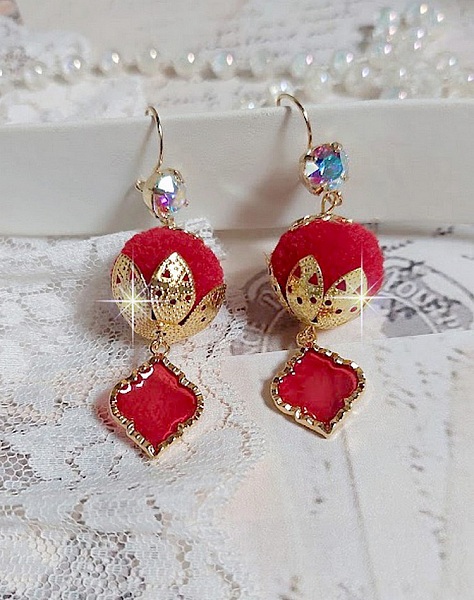 BO Passionn&eacute;ment mont&eacute;es avec des pompons Rouges tr&egrave;s tendances &agrave; laquelle s&rsquo;ajoute des coupelles en forme d&rsquo;arabesque, pendentifs vitrail Rouge/Dor&eacute; et cabochons en Cristal AB sur crochets en Laiton