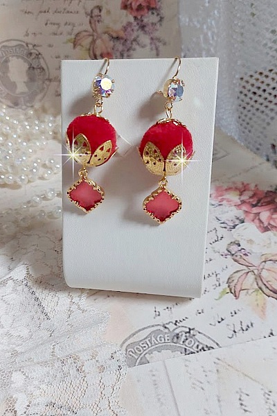 BO Passionn&eacute;ment mont&eacute;es avec des pompons Rouges tr&egrave;s tendances &agrave; laquelle s&rsquo;ajoute des coupelles en forme d&rsquo;arabesque, pendentifs vitrail Rouge/Dor&eacute; et cabochons en Cristal AB sur crochets en Laiton