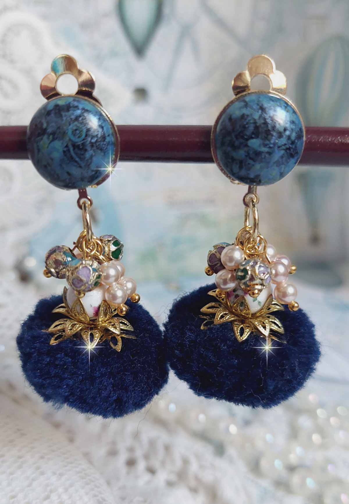 Boucles d'oreilles clips avec pompons bleus et perles Swarovski.