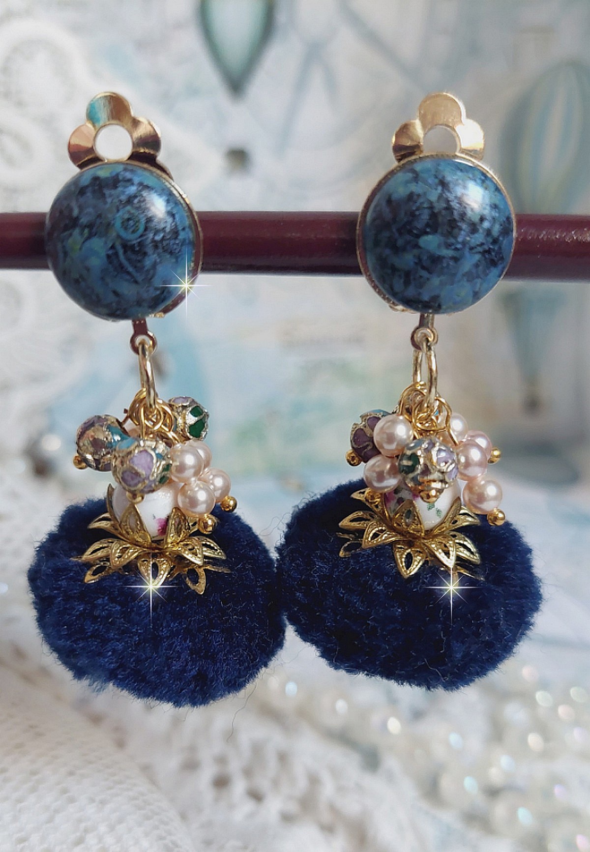 Boucles d'oreilles clips avec pompons bleus et perles Swarovski.