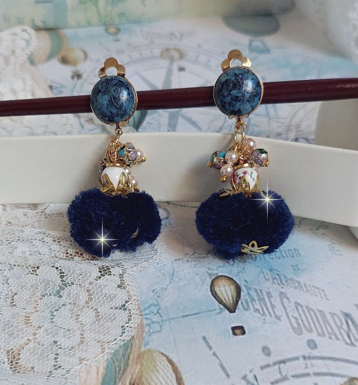 Boucles d'oreilles clips avec pompons bleus et perles Swarovski.