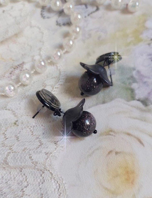 Boucles d'oreilles puces fleurs noires et perles scintillantes.