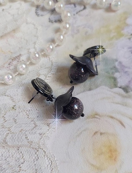 Boucles d'oreilles puces fleurs noires et perles scintillantes.