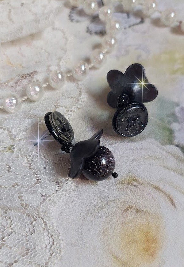 Boucles d'oreilles puces fleurs noires et perles scintillantes.