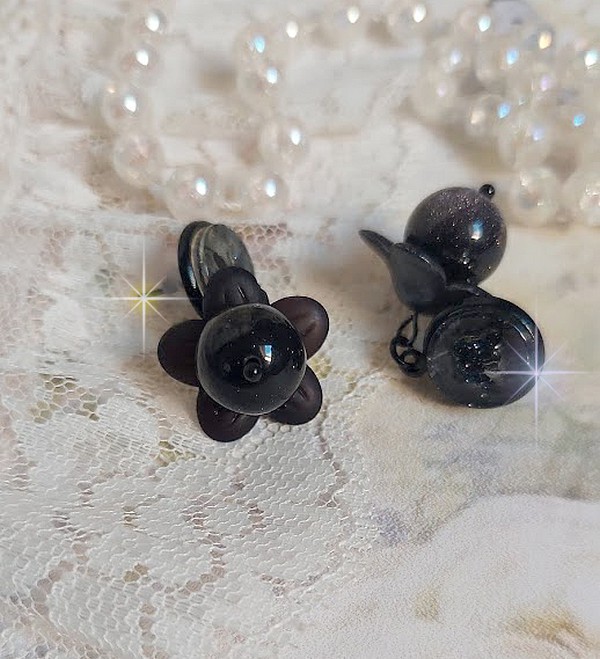Boucles d'oreilles fleurs noires avec perles et cabochons brillants.