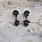Boucles d'oreilles pendantes noires avec fleurs et perles scintillantes.