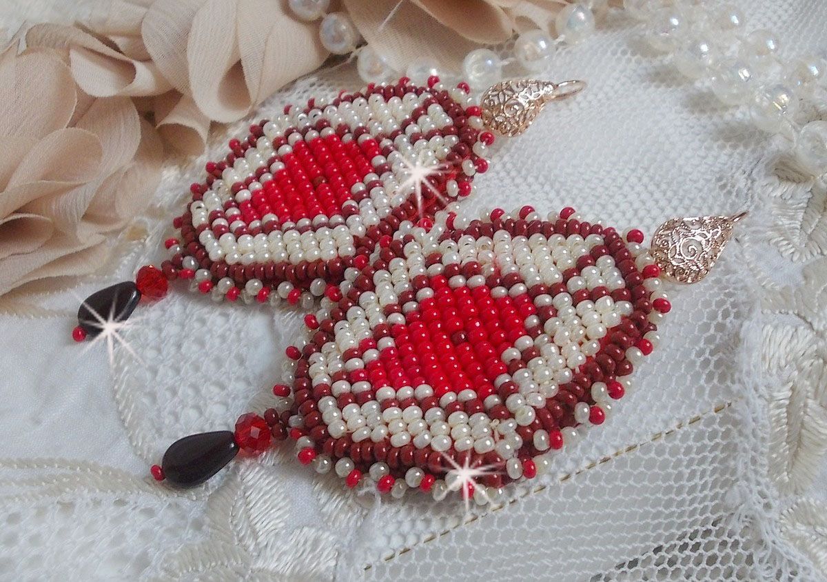 BO Romane brod&eacute;es avec des rocailles en verre Rouge, Bordeaux, Ivoire &agrave; laquelle s'ajoute des gouttes plates Grenat. Le tout est mont&eacute; sur des crochets en Laiton d&eacute;cor goutte