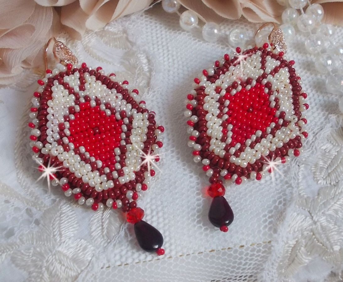 BO Romane brod&eacute;es avec des rocailles en verre Rouge, Bordeaux, Ivoire &agrave; laquelle s'ajoute des gouttes plates Grenat. Le tout est mont&eacute; sur des crochets en Laiton d&eacute;cor goutte