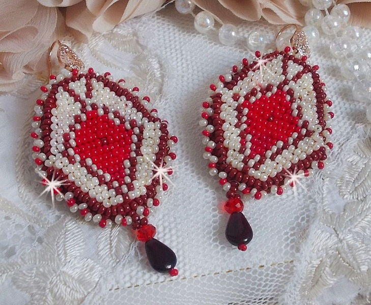 BO Romane brod&eacute;es avec des rocailles en verre Rouge, Bordeaux, Ivoire &agrave; laquelle s'ajoute des gouttes plates Grenat. Le tout est mont&eacute; sur des crochets en Laiton d&eacute;cor goutte