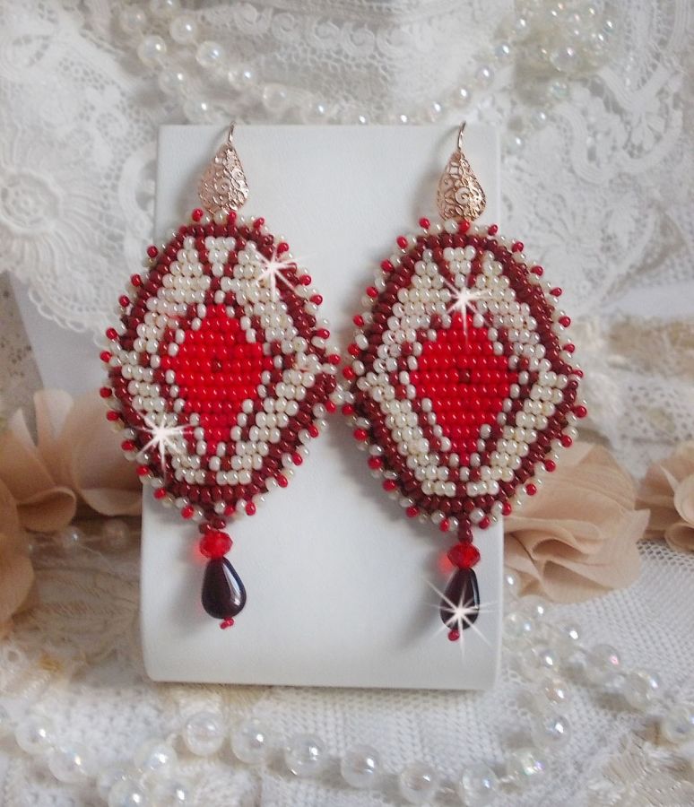 BO Romane brod&eacute;es avec des rocailles en verre Rouge, Bordeaux, Ivoire &agrave; laquelle s'ajoute des gouttes plates Grenat. Le tout est mont&eacute; sur des crochets en Laiton d&eacute;cor goutte