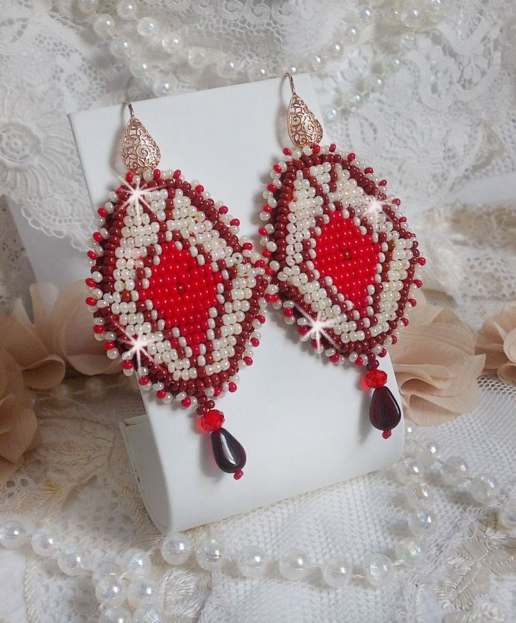 BO Romane brod&eacute;es avec des rocailles en verre Rouge, Bordeaux, Ivoire &agrave; laquelle s'ajoute des gouttes plates Grenat. Le tout est mont&eacute; sur des crochets en Laiton d&eacute;cor goutte