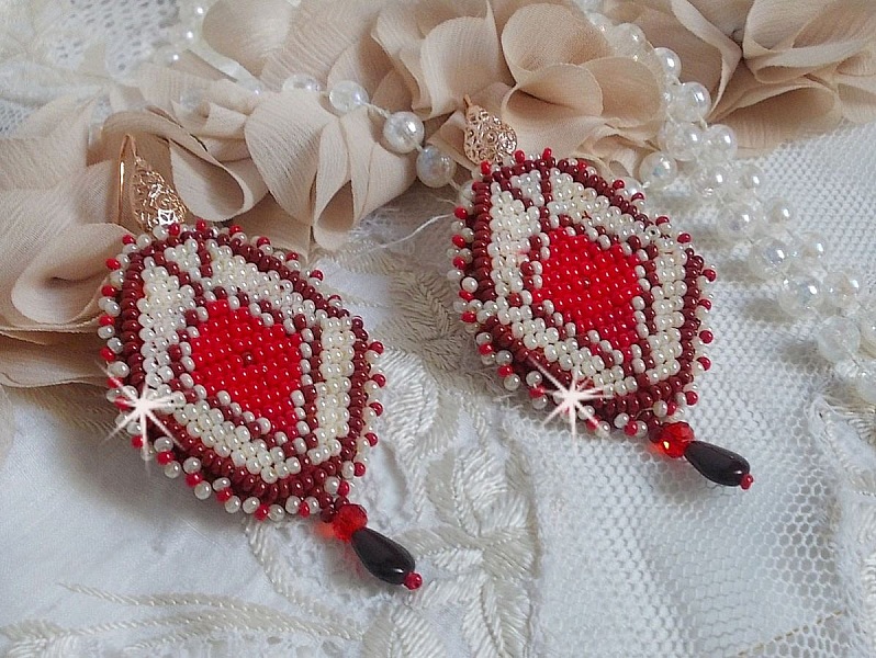 BO Romane brod&eacute;es avec des rocailles en verre Rouge, Bordeaux, Ivoire &agrave; laquelle s'ajoute des gouttes plates Grenat. Le tout est mont&eacute; sur des crochets en Laiton d&eacute;cor goutte