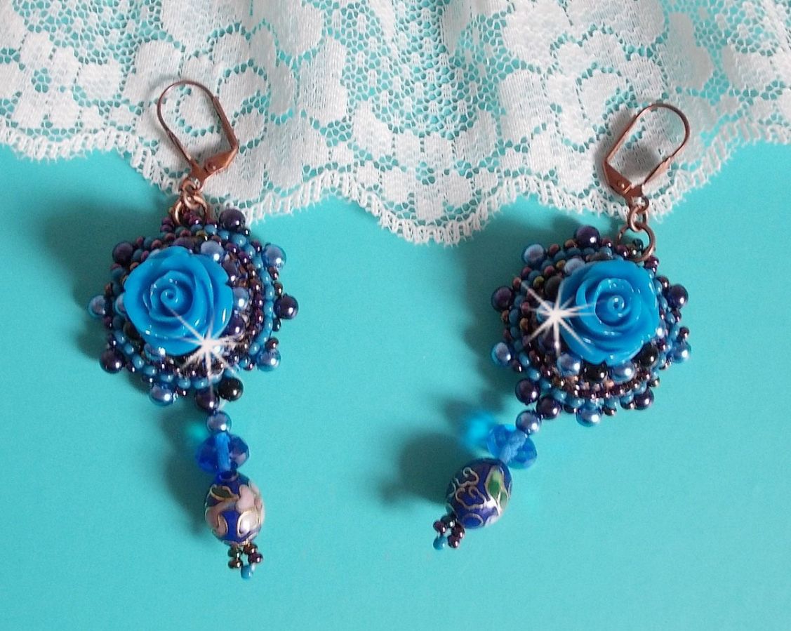 BO Roses Bleues Royales sont brod&eacute;es avec des roses en r&eacute;sine Bleu, des perles rondes nacr&eacute;es, perles cloisonn&eacute;es porcelaine et des rocailles. Le tout est mont&eacute; sur des dormeuses en Laiton