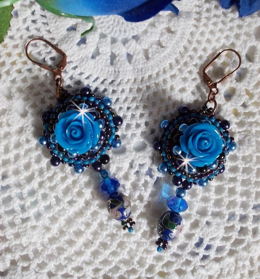 BO Roses Bleues Royales sont brod&eacute;es avec des roses en r&eacute;sine Bleu, des perles rondes nacr&eacute;es, perles cloisonn&eacute;es porcelaine et des rocailles. Le tout est mont&eacute; sur des dormeuses en Laiton