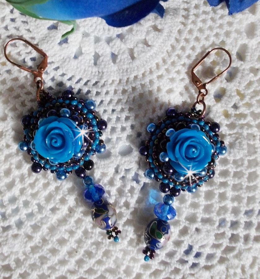 BO Roses Bleues Royales sont brod&eacute;es avec des roses en r&eacute;sine Bleu, des perles rondes nacr&eacute;es, perles cloisonn&eacute;es porcelaine et des rocailles. Le tout est mont&eacute; sur des dormeuses en Laiton