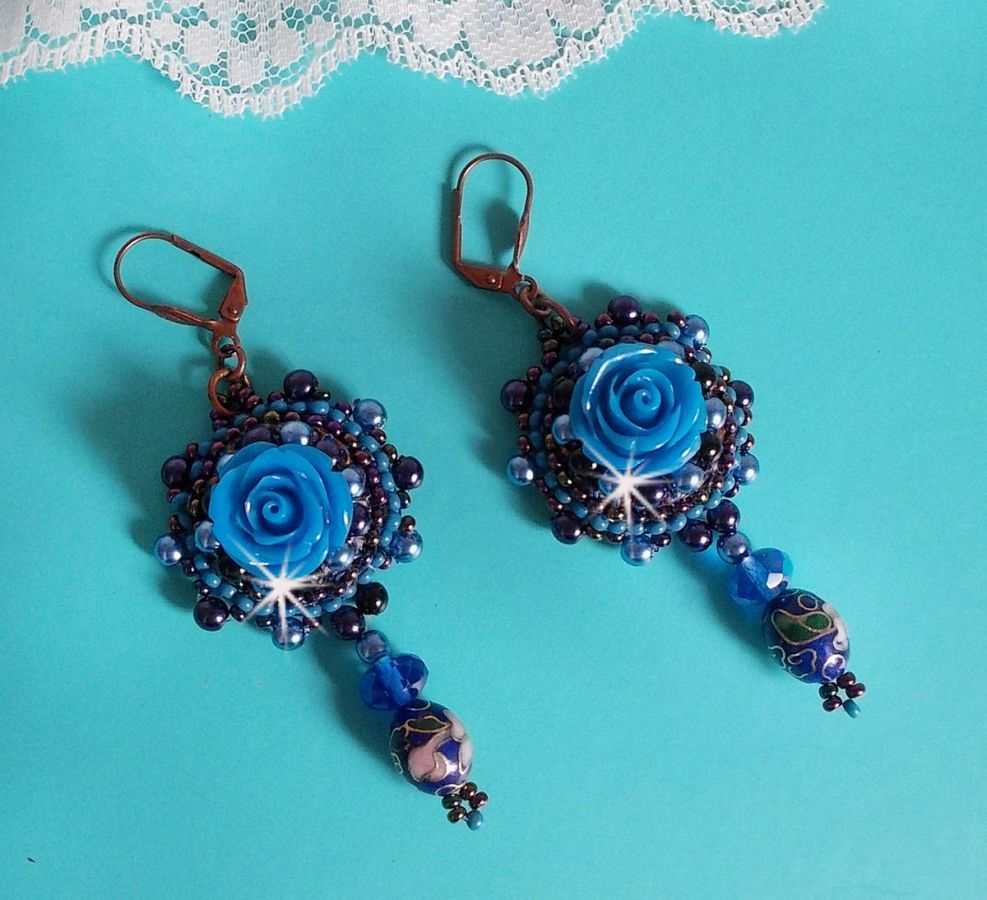 BO Roses Bleues Royales sont brod&eacute;es avec des roses en r&eacute;sine Bleu, des perles rondes nacr&eacute;es, perles cloisonn&eacute;es porcelaine et des rocailles. Le tout est mont&eacute; sur des dormeuses en Laiton
