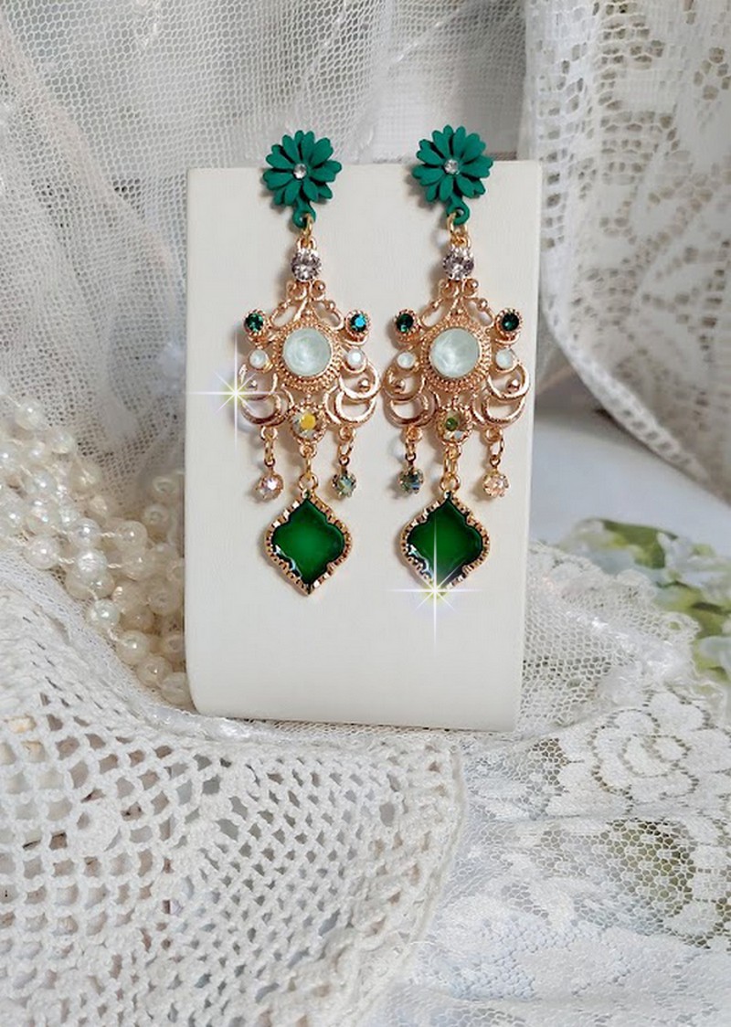 BO Royal Marguerite mont&eacute;es avec des cabochons &agrave; laquelle s&rsquo;ajoute des strass sur les pendentifs Dor&eacute;s. Les pendants sont en r&eacute;sine &eacute;poxy avec clous d&rsquo;oreilles &eacute;maill&eacute;s