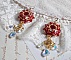 BO Rubis brod&eacute;es avec des cabochons Light Siam orn&eacute;s de toupies Rouges &agrave; laquelle s&rsquo;ajoute perles nacr&eacute;es Ivoires, estampes Dor&eacute;es, gouttes baroques en Cristal AB et crochets en Gold Filled 14 carats
