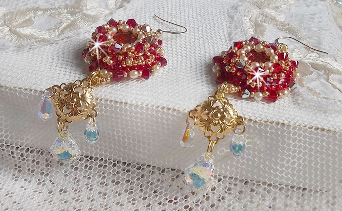 BO Rubis brod&eacute;es avec des cabochons Light Siam orn&eacute;s de toupies Rouges &agrave; laquelle s&rsquo;ajoute perles nacr&eacute;es Ivoires, estampes Dor&eacute;es, gouttes baroques en Cristal AB et crochets en Gold Filled 14 carats