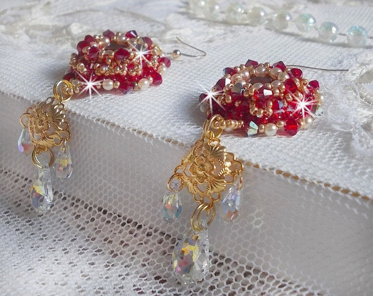 BO Rubis brod&eacute;es avec des cabochons Light Siam orn&eacute;s de toupies Rouges &agrave; laquelle s&rsquo;ajoute perles nacr&eacute;es Ivoires, estampes Dor&eacute;es, gouttes baroques en Cristal AB et crochets en Gold Filled 14 carats