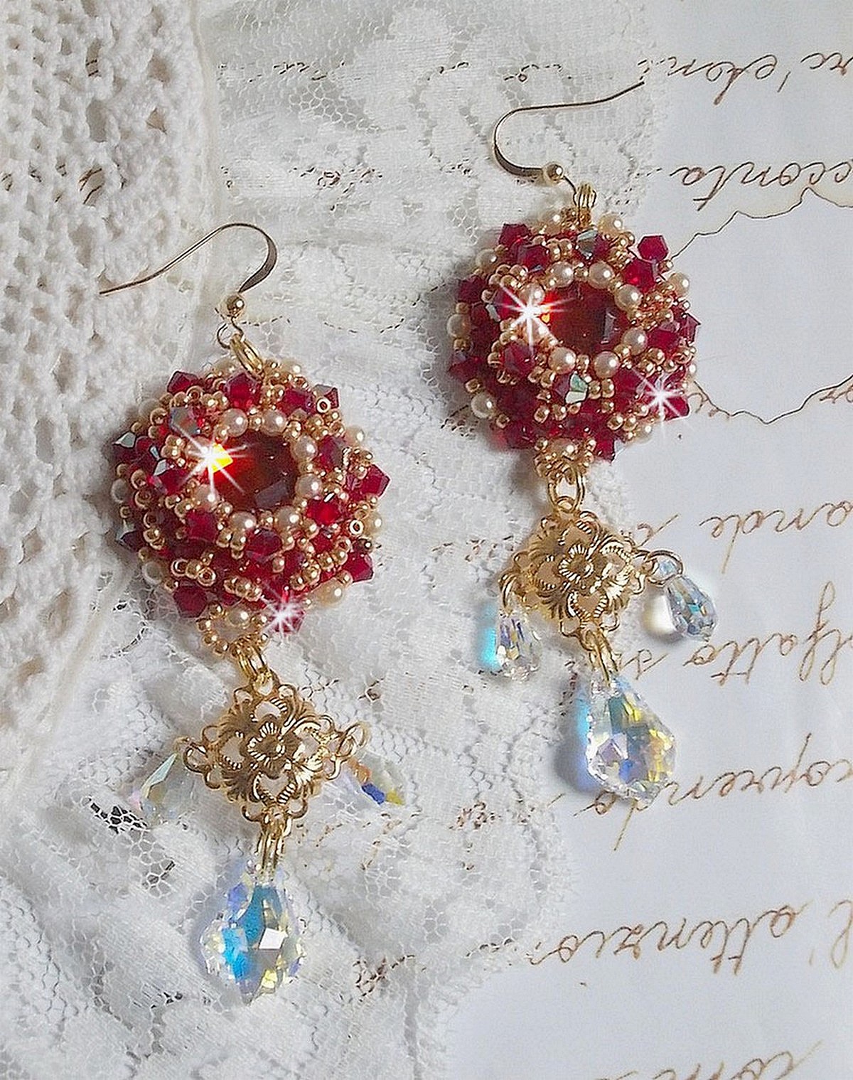 BO Rubis brod&eacute;es avec des cabochons Light Siam orn&eacute;s de toupies Rouges &agrave; laquelle s&rsquo;ajoute perles nacr&eacute;es Ivoires, estampes Dor&eacute;es, gouttes baroques en Cristal AB et crochets en Gold Filled 14 carats