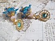 Boucles d'oreilles pendantes fleurs bleues, perles roses et cristaux.