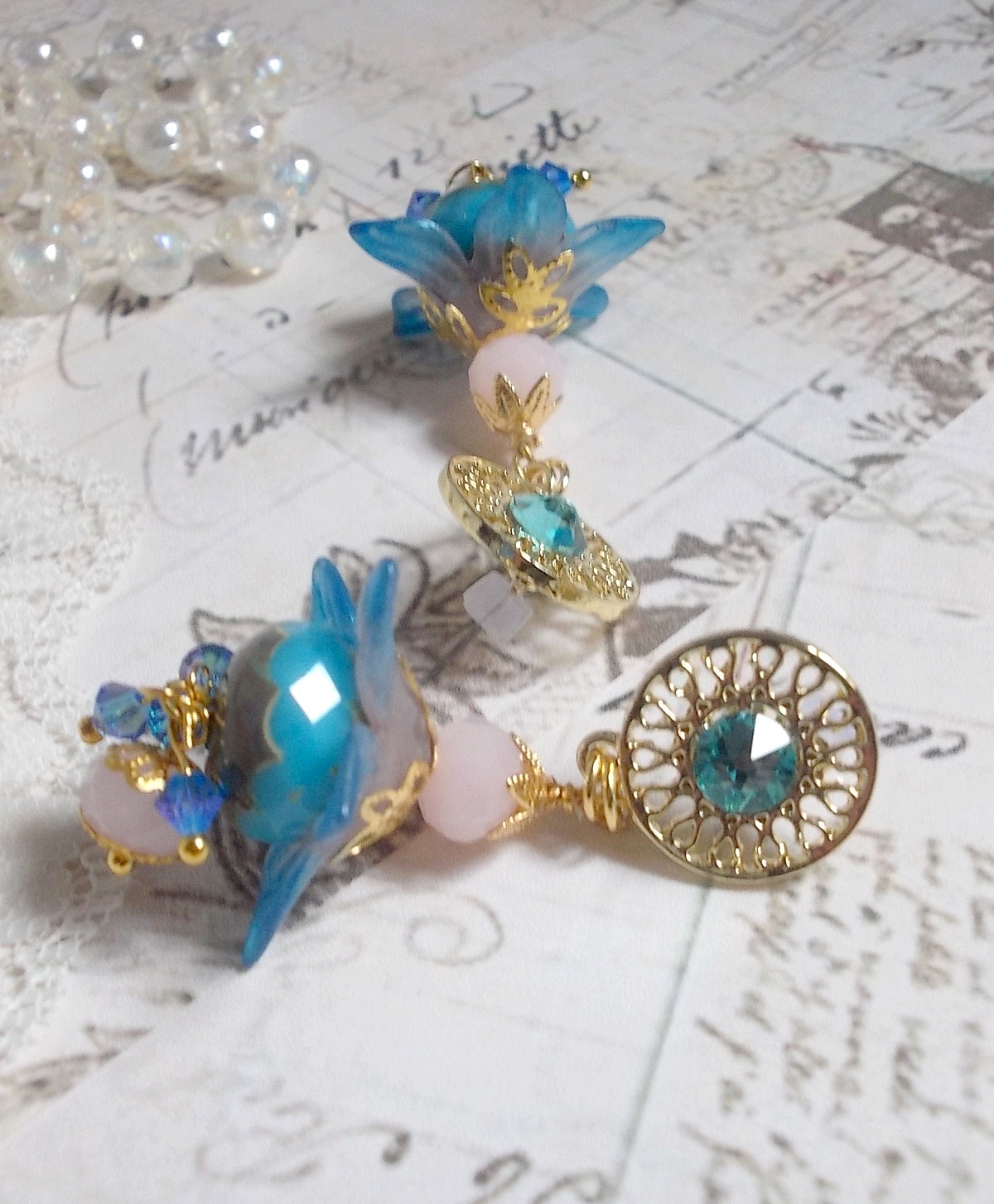 Boucles d'oreilles pendantes fleurs bleues, perles roses et cristaux.