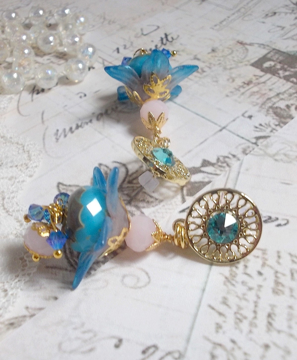 Boucles d'oreilles pendantes fleurs bleues, perles roses et cristaux.